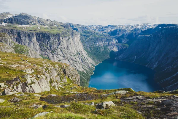 Een levendig beeld van beroemde Noorse wandelen plaats - manier om de trolltunga, de trollen tong, rots skjegedall, met een toerist, en weergave epische bij panoramische landschap van lake ringedalsvatnet en berg, Noorwegen — Stockfoto