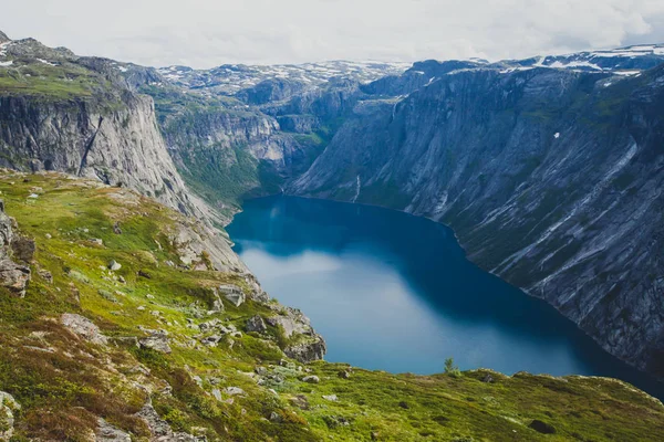 Яркая картинка известного норвежского места для пеших прогулок - путь к троллям, троллям, скалам, скалам, с туристом, а также озеру Рингедалсватнет и горному панорамному пейзажу, Норвегия — стоковое фото