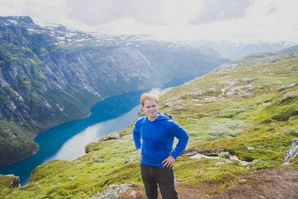 A vibrant picture of famous norwegian hiking place - way to trolltunga, the trolls tongue, rock skjegedall, with a tourist, and lake ringedalsvatnet and mountain panoramic scenery epic view, Norway — Stock Photo, Image