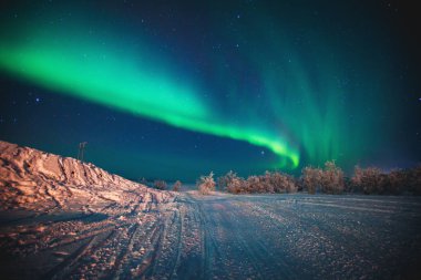 Aynı zamanda kış Lapland peyzaj, Norveç, Iskandinavya üzerinde gece gökyüzünde kuzey ışıkları olarak bilinen Massive renkli yeşil canlı Aurora Borealis güzel resim, 