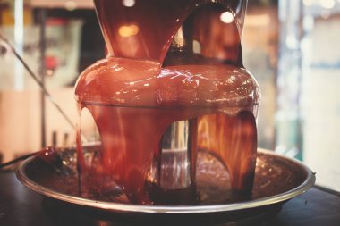 Canlı resim, çikolata çeşmesi Fontain üzerinde çıkarmaya uğraşırken bir çocuğu olan doğum günü partisi çocuklar ve şekerleme ve meyve dip çeşme daldırma