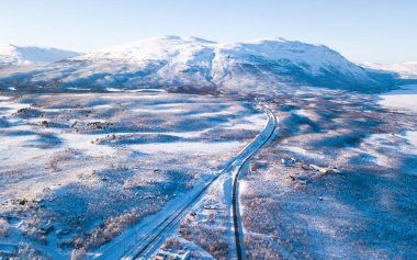 Abisko Milli Parkı, Kiruna Belediyesi, Lapland Norrbotten County, İsveç, hava güneşli kış görünümünü dron, yol ve dağ üzerinden vurdu