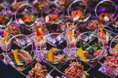 Güzel dekore edilmiş yemek masası farklı atıştırmalıklar ve aperatiflerle kurumsal noel partisi, düğün kutlaması, farklı vejetaryen aperatifler. 