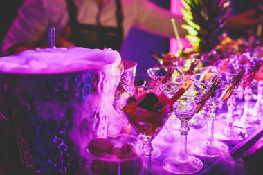 Yemek masasında alkol ayarı, bir partide sıra sıra değişik renkte alkol kokteylleri, martini, votka ve dekore edilmiş buket masasında diğerleri. 