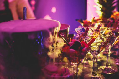 Yemek masasında alkol ayarı, bir partide sıra sıra değişik renkte alkol kokteylleri, martini, votka ve dekore edilmiş buket masasında diğerleri. 