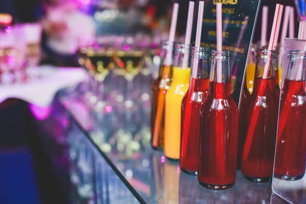 Вид на атмосферу на банкетний стіл, рядок лінії різних кольорових алкогольних коктейлів на вечірці, мартіні, горілці та інших на прикрашеному столі для їдалень — стокове фото