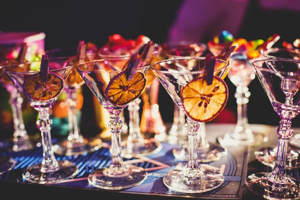 View of alcohol setting on catering banquet table, row line of different colored alcohol cocktails on a party, martini, vodka, and others on decorated catering bouquet table event — 스톡 사진