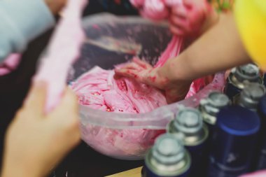 Çocukların doğum günü partisinde çok renkli balçık, pembe, mavi ve beyaz sümük oyuncağı yapan bir grup çocuk, sümükle oynayan çocuk, ev yapımı balçık.