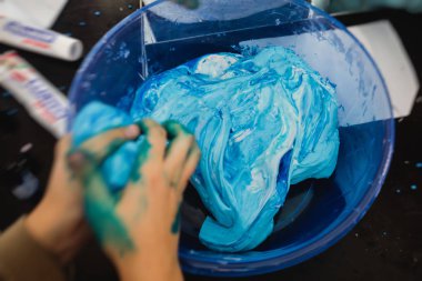 Çocukların doğum günü partisinde çok renkli balçık, pembe, mavi ve beyaz sümük oyuncağı yapan bir grup çocuk, sümükle oynayan çocuk, ev yapımı balçık.