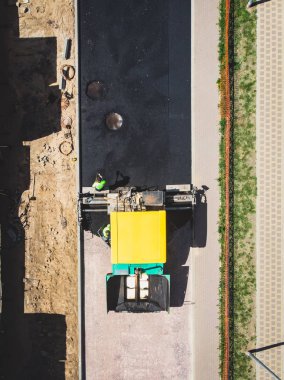 Yol yapımı sırasında asfalt kaldırım makinesi ve buharlı yol silindiri ve tamirat işleri, asfaltlama ve asfalt döşeme süreci, yeni yol inşaatında çalışan işçiler, katman yerleştirme, insansız hava aracı 