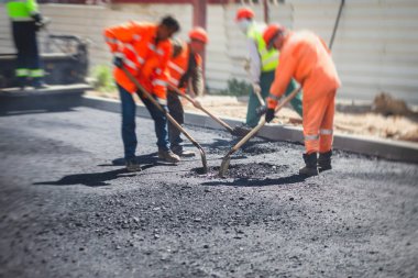 Yol yapımı sırasında asfalt kaldırım makinesi ve buharlı yol silindiri ve tamirat işleri, asfaltlama ve asfalt döşeme süreci, yeni yol inşaatında çalışan işçiler, bir katman yerleştirme