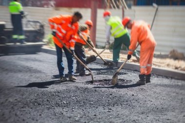 Yol yapımı sırasında asfalt kaldırım makinesi ve buharlı yol silindiri ve tamirat işleri, asfaltlama ve asfalt döşeme süreci, yeni yol inşaatında çalışan işçiler, bir katman yerleştirme
