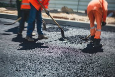 Yol yapımı sırasında asfalt kaldırım makinesi ve buharlı yol silindiri ve tamirat işleri, asfaltlama ve asfalt döşeme süreci, yeni yol inşaatında çalışan işçiler, bir katman yerleştirme