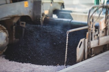 Yol yapımı sırasında asfalt kaldırım makinesi ve buharlı yol silindiri ve tamirat işleri, asfaltlama ve asfalt döşeme süreci, yeni yol inşaatında çalışan işçiler, bir katman yerleştirme