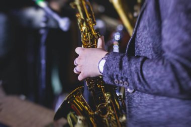 Caz grubu sırasında vokalist ve müzikal olan profesyonel saksafoncu bir kadının konser görüntüsü.