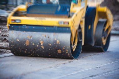 Yol yapımı sırasında asfalt kaldırım makinesi ve buharlı yol silindiri ve tamirat işleri, asfaltlama ve asfalt döşeme süreci, yeni yol inşaatında çalışan işçiler, bir katman yerleştirme