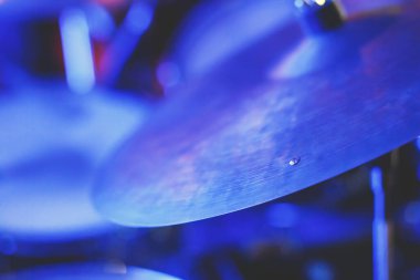 Rock gösterisi sırasında sahnede davul setinin görüntüsü, arka planda bando performansı, baterist bakış açısı