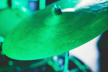 Rock gösterisi sırasında sahnede davul setinin görüntüsü, arka planda bando performansı, baterist bakış açısı