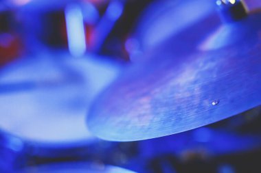 Rock gösterisi sırasında sahnede davul setinin görüntüsü, arka planda bando performansı, baterist bakış açısı