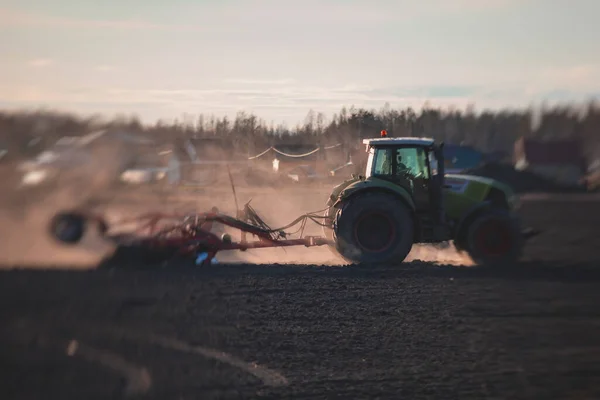 디스크 시스템을 트랙터는 경작지를 황폐시키고 토양을 단단하게 준비하는 석양에 밭에서 — 스톡 사진