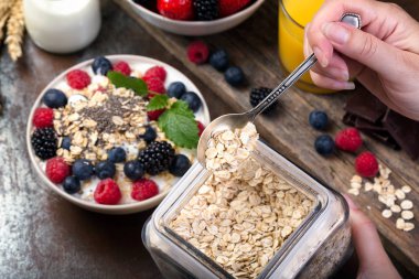 Spoon of oatmeal. Bowl with berries.