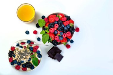 Bowl of berries with orange juice and chocolate