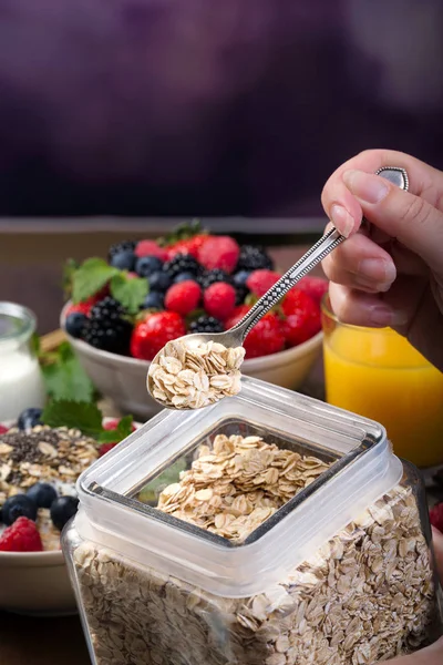Spoon of oatmeal. Bowl with berries.