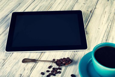 Kahve ve tablet masanın üstünde.