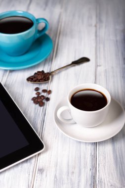 Kahve ve tablet masanın üstünde.