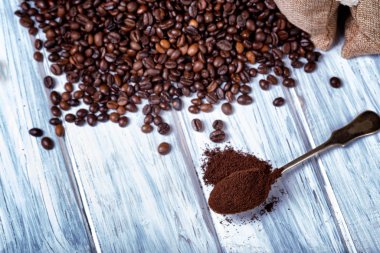 Kahve çekirdeği ve kaşık içinde öğütülmüş kahve..