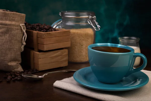 Tazza di caffè e sacchetti di iuta, contenitore di legno, zucchero di canna — Foto Stock