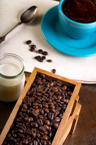 Taza de café y contenedores de madera llenos de granos de cofee — Foto de Stock