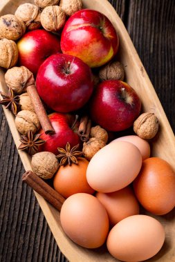 Elma, yumurta ve cevizli ahşap kase.