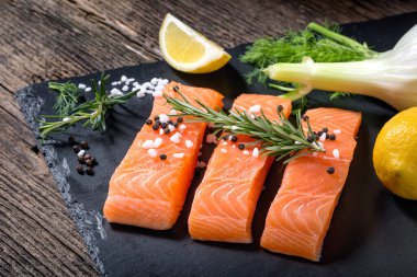 Salmon filet sliced on three parts with lime and herbs.