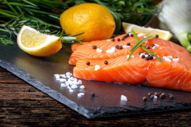 Salmon filet sliced on three parts with lime and herbs.