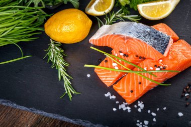 Salmon filet sliced on three parts with lime and herbs.