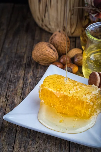 Tarro de miel y panal de abeja, frutos secos de diversos tipos —  Fotos de Stock