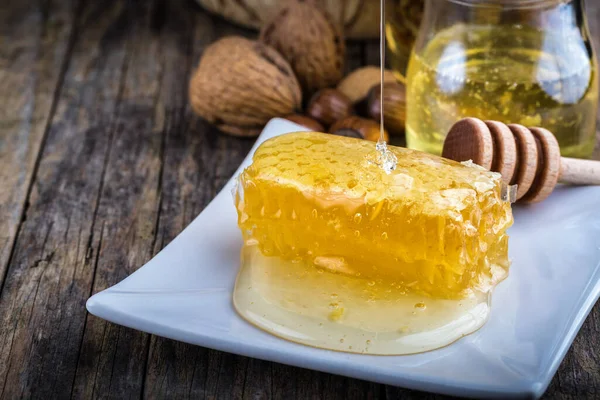 Tarro de miel y panal de abeja, frutos secos de diversos tipos —  Fotos de Stock