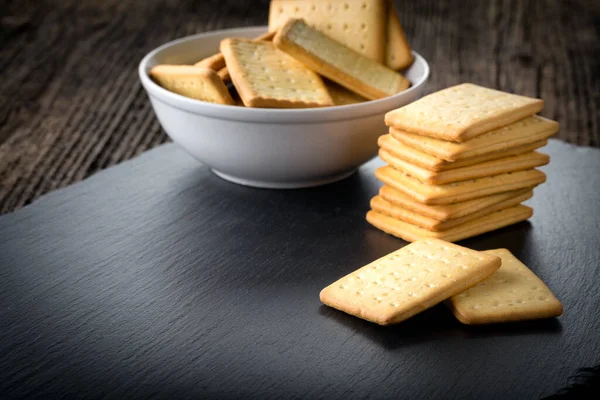 Dry salted crackers in a bowl on granite plate — Stock Photo, Image