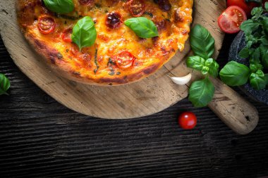 Mozzarella, fesleğen ve domatesli ev yapımı pizza margherita.