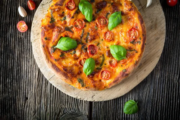 Mozzarella, fesleğen ve domatesli ev yapımı pizza margherita.