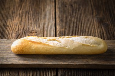 Ahşap bir arka planda taze pişmiş beyaz ekmek.