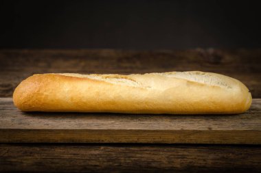 Ahşap bir arka planda taze pişmiş beyaz ekmek.