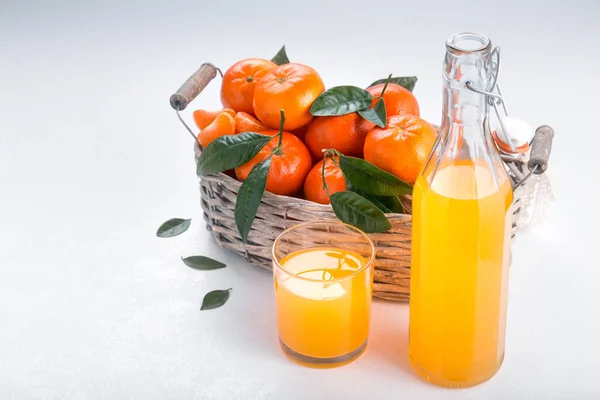 Cesta llena de mandarina con un vaso de jugo — Foto de Stock