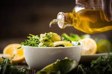 pouring olive oil to lettuce