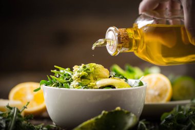 pouring olive oil to lettuce