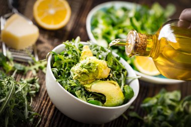 pouring olive oil to lettuce