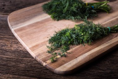 Tahtada dilimlenmiş dereotu dalı