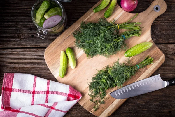 Sliced twig of dill on a wooden board with cucumber, kknife and — Stock Photo, Image