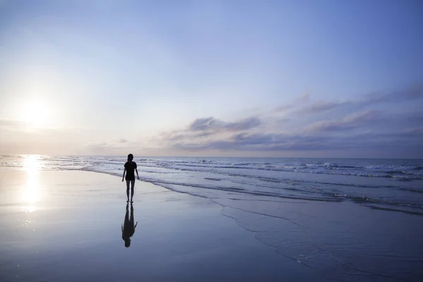 Kobieta na plaży w sunrise — Zdjęcie stockowe